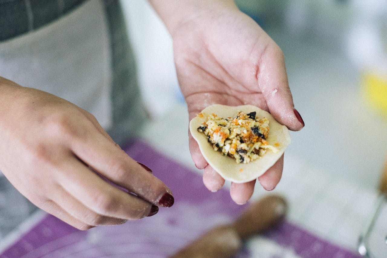 A detailed view of the process of preparing homemade dumplings with vegetable filling.